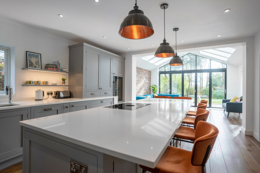 Light grey shaker kitchen with orange stools and lamps