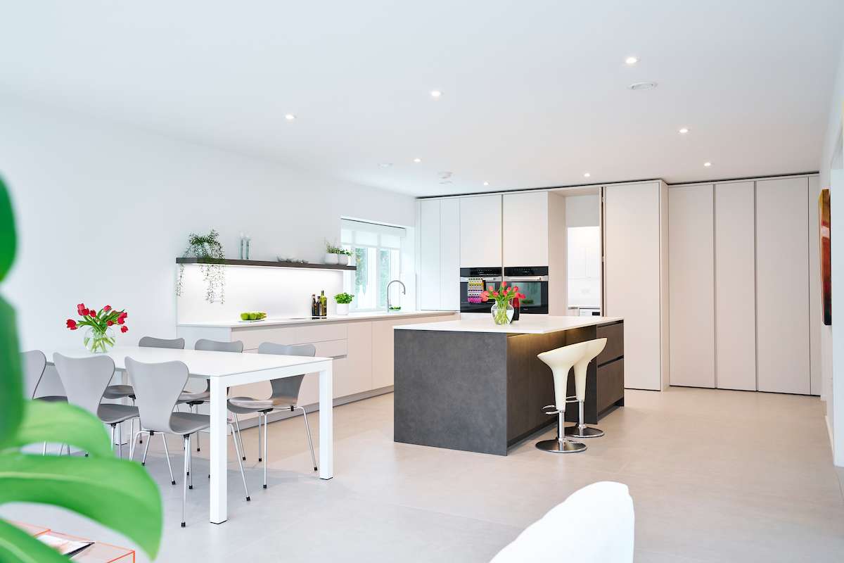 high-end kitchen design showcasing integrated appliances and seamless white cabinetry