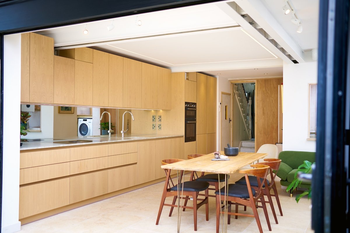 oak contemporary kitchen with limestone flooring and bifold doors