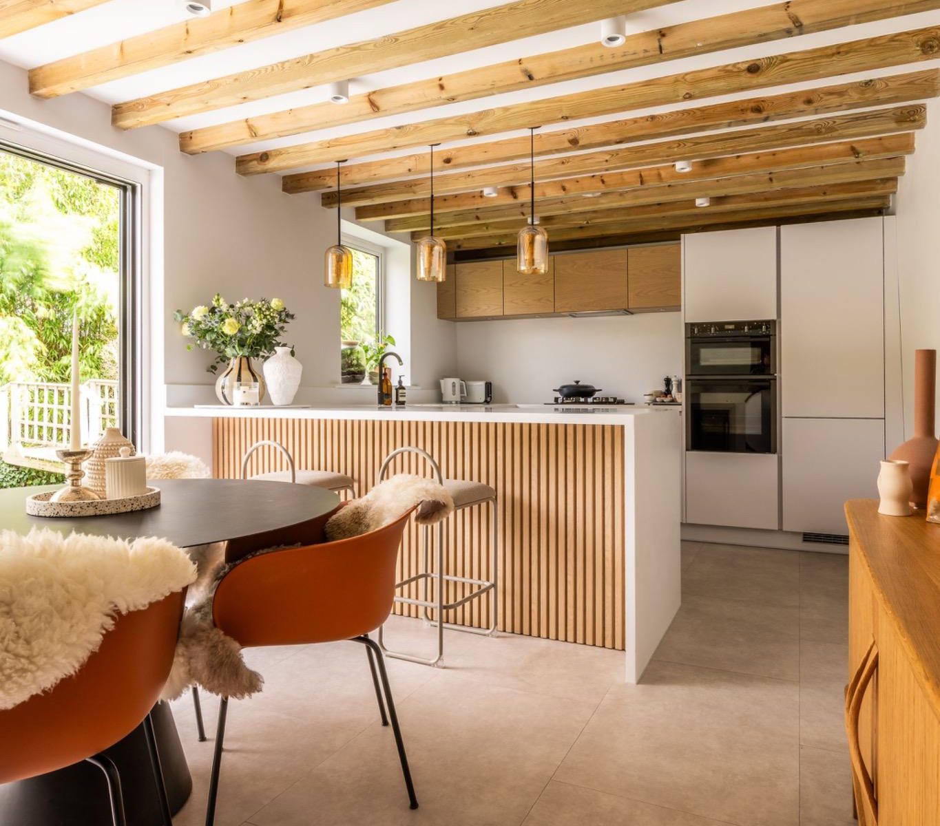 Bright kitchen with natural light, exposed timber beams and modern breakfast bar