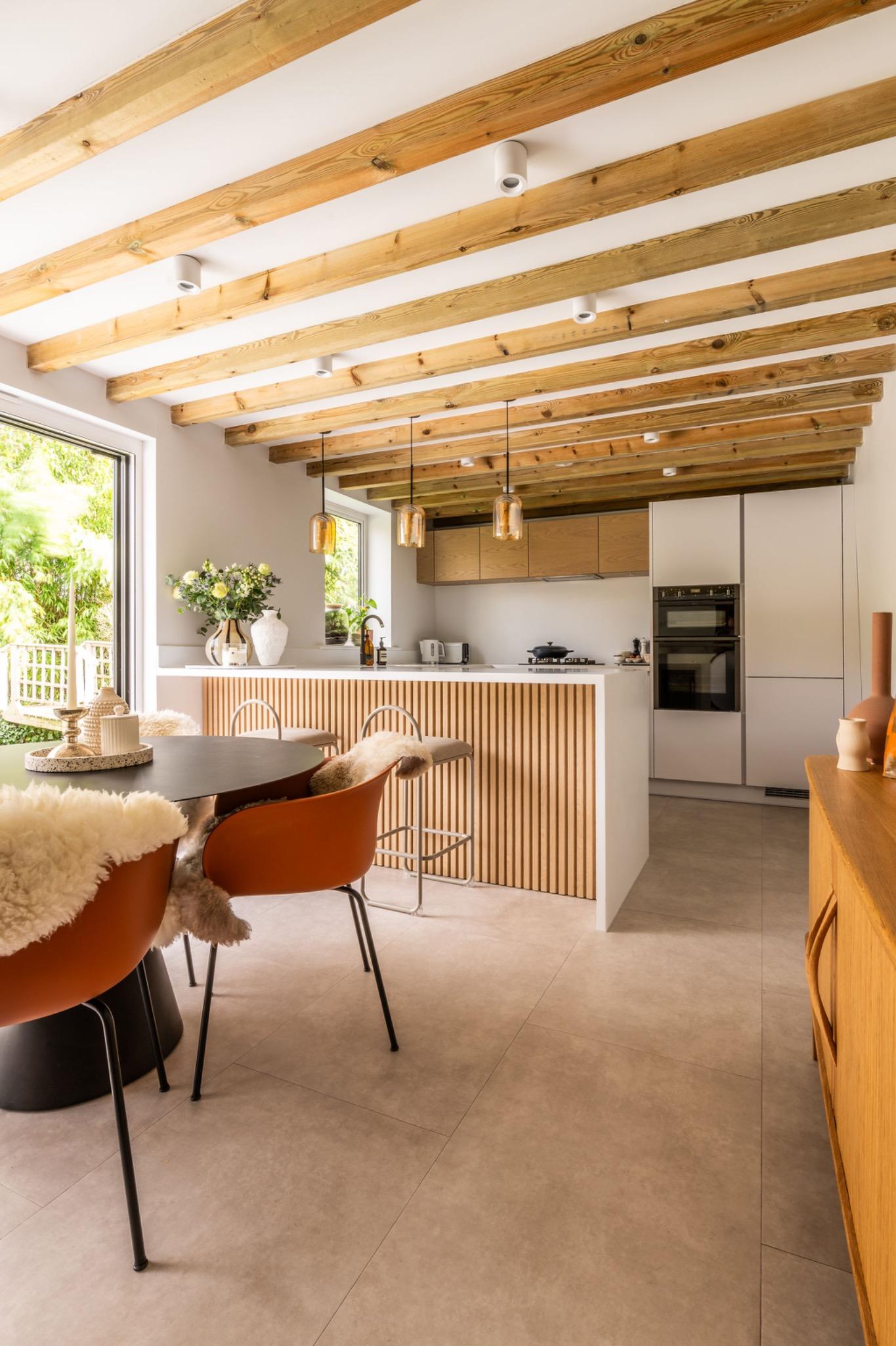 Bright kitchen with natural light, exposed timber beams and modern breakfast bar